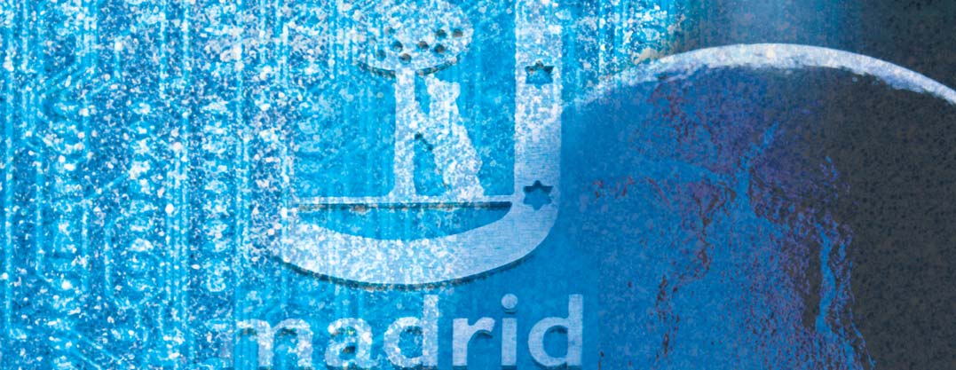 Imagen de un mapamundi con el escudo de la ciudad de Madrid