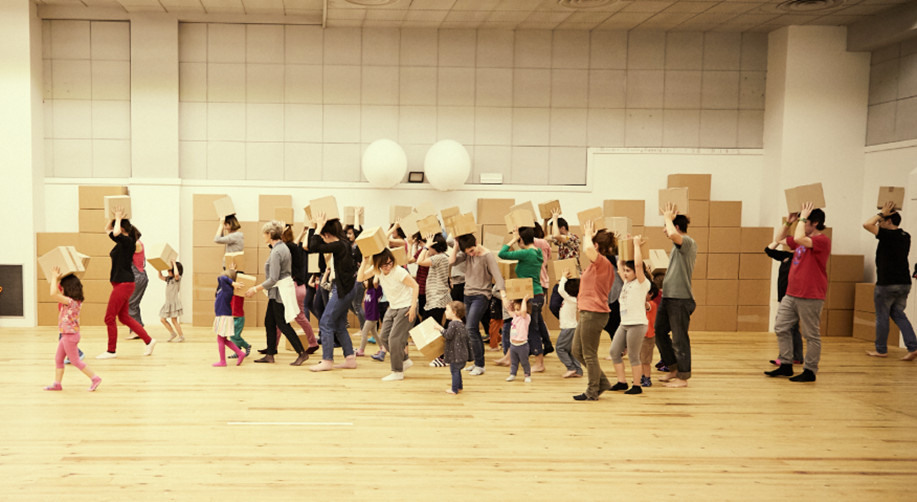 Ni&ntilde;as, ni&ntilde;os y personas adultas jugando en un gimnasio