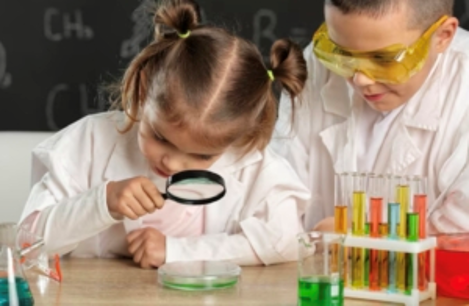 Una ni&ntilde;a observa algo con lupa y un ni&ntilde;o la mira
