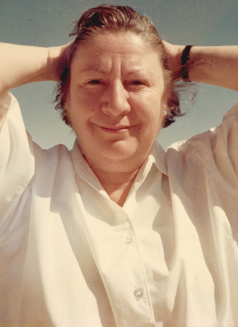 Mujer sonr&iacute;e con las manos tras la nuca