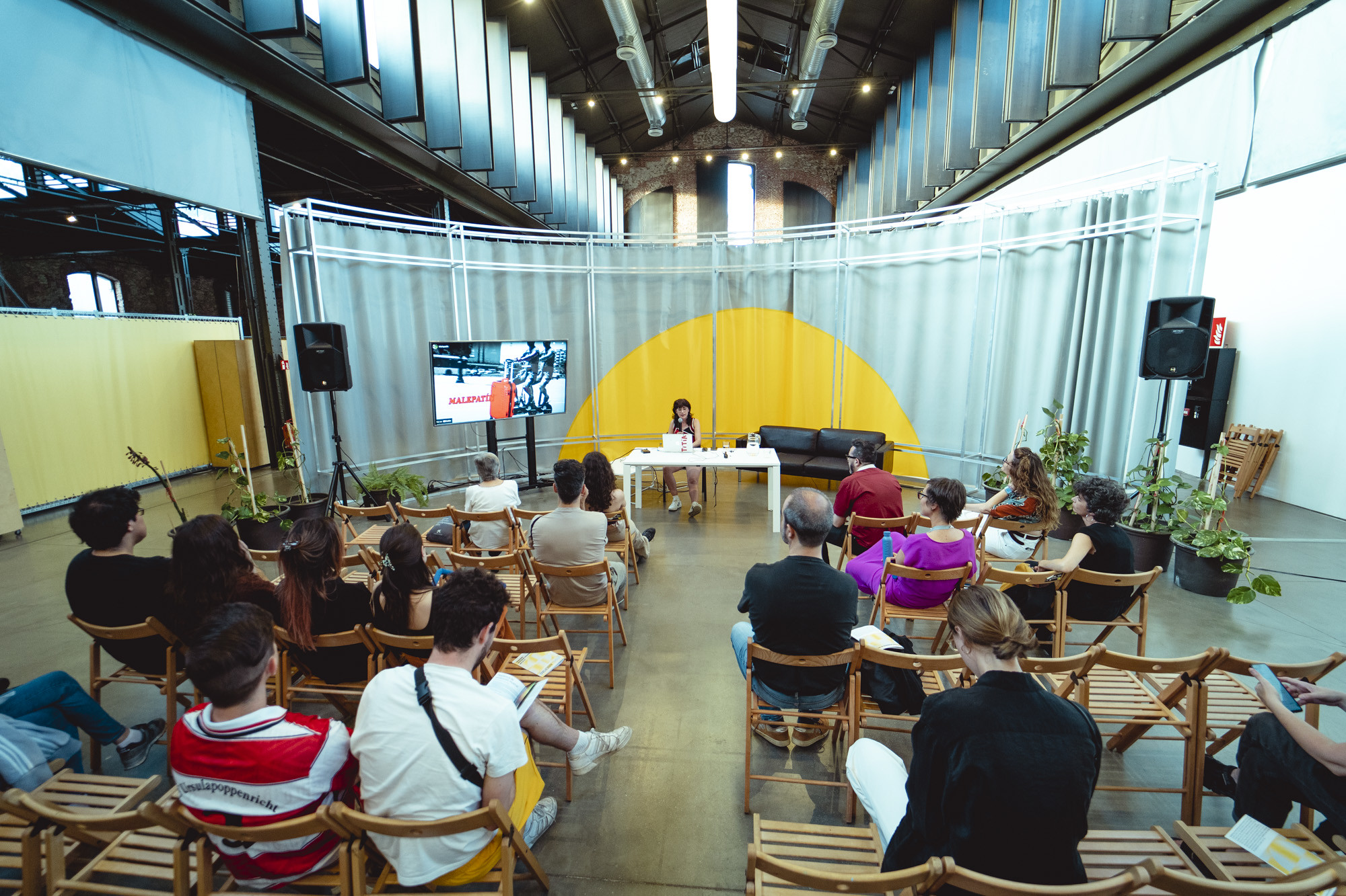 ponente da una charla con un tel&oacute;n de fondo