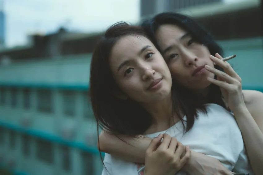 Dos mujeres miran al cielo abrazadas, una fuma