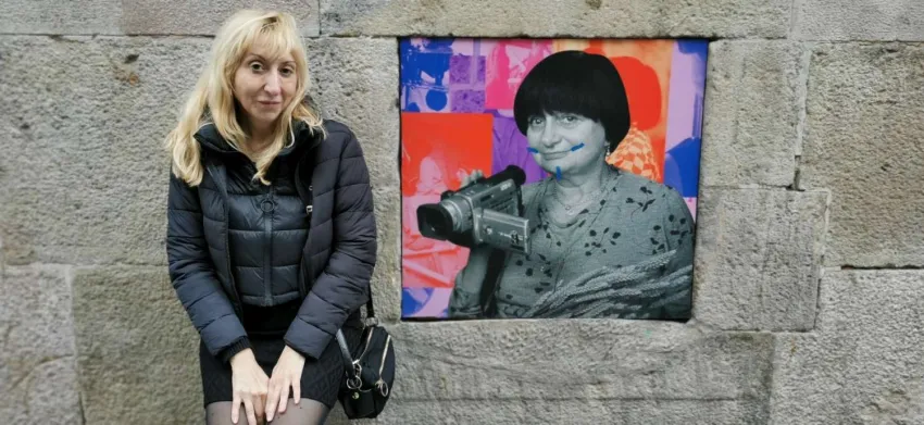 Una mujer posa junto a un cartel de otra mujer vandalizado