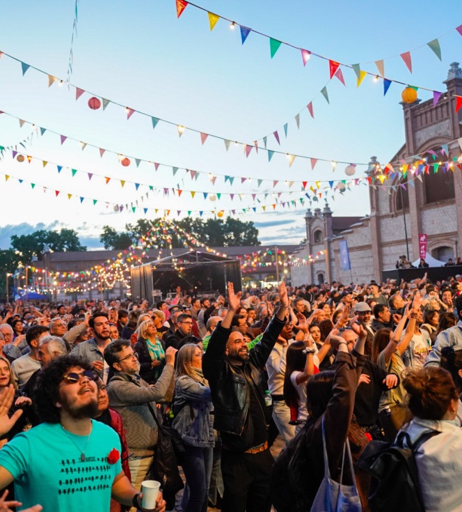 P&uacute;blico mira al un escenario divirti&eacute;ndose al atardecer