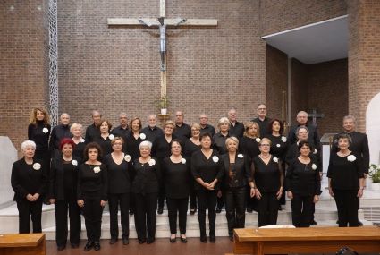 Foto de un grupo de hombre y mujeres cantando en una iglesia. Una coral