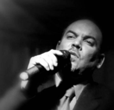 Un hombre con un micr&oacute;fono cantando