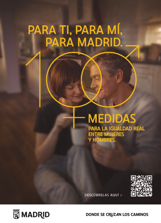 Cartel vertical con una fotograf&iacute;a en primer plano de dos personas adultas interactuando en un espacio interior c&aacute;lido. Se aprecia una situaci&oacute;n de conversaci&oacute;n cercana, cotidiana, que transmite conexi&oacute;n y complicidad. A la izquierda, sobre un fondo oscuro, aparece el mensaje en letras amarillas: &ldquo;Para ti, para m&iacute;, para Madrid. Medidas para la igualdad real entre mujeres y hombres. Desc&uacute;brelas aqu&iacute; 