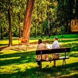 mujer y hombre sentados en banco en el parque