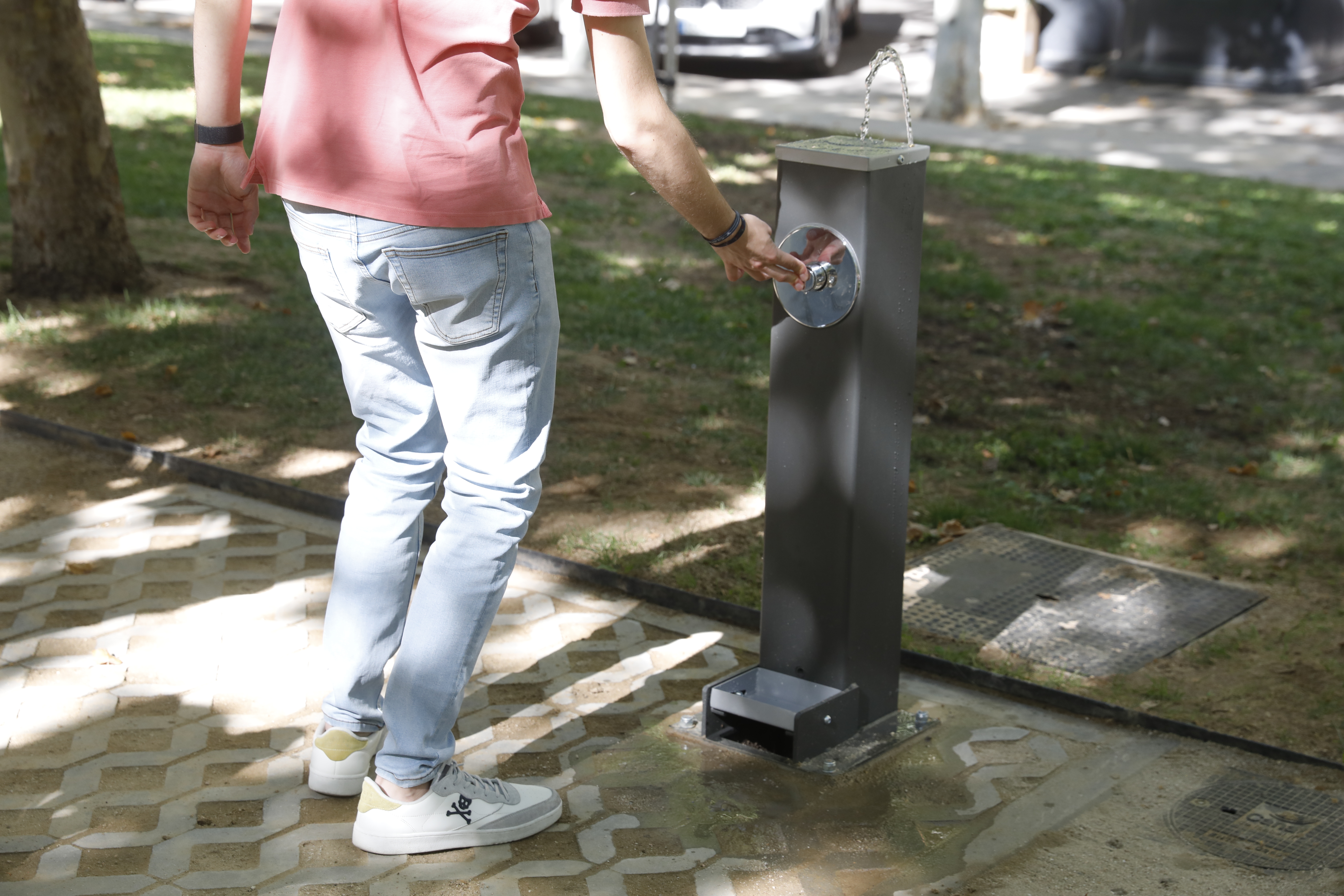 Joven utiliza una fuente de agua potable