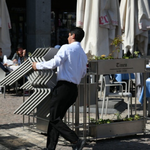 Un-trabajador-de-la-hosteleria-coloca-unas-sillas-en-la-plaza-Mayor