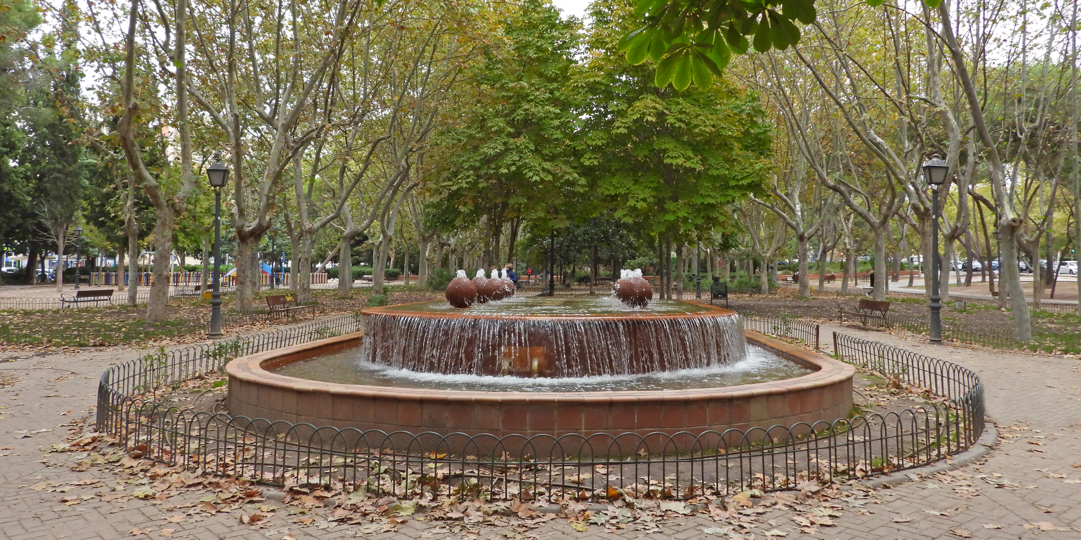 se observa una fuente rodeada de caminos de tierra y &aacute;rboles